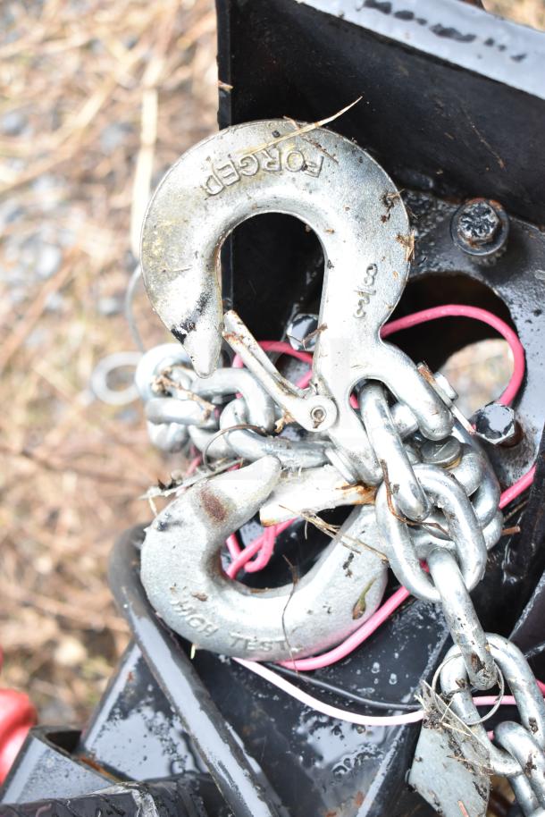 Close-up of a heavy-duty metal chain and hook system attached to the 2020 Southern Dimensions Group mobile trailer hitch.