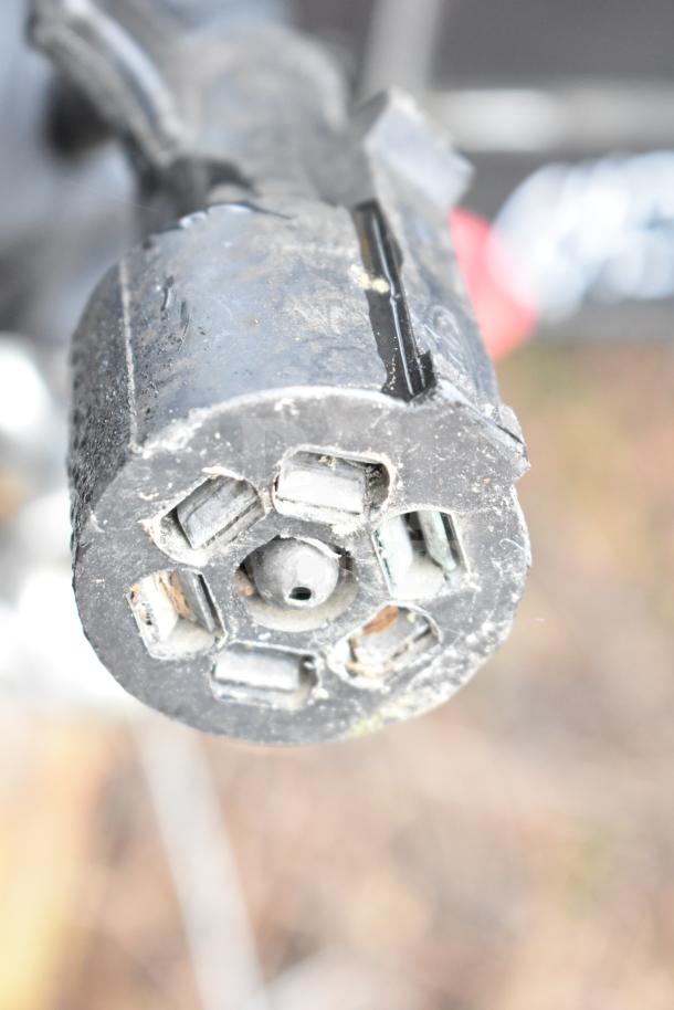 Close-up of the trailer's black electrical connector, showing wear. Part of a 2020 Southern Dimensions Group mobile commissary trailer.