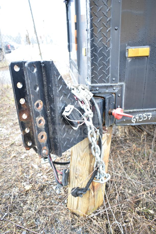 All-black mobile commissary trailer hitch with chain and plug, featuring a visible VIN 64357 on metal.