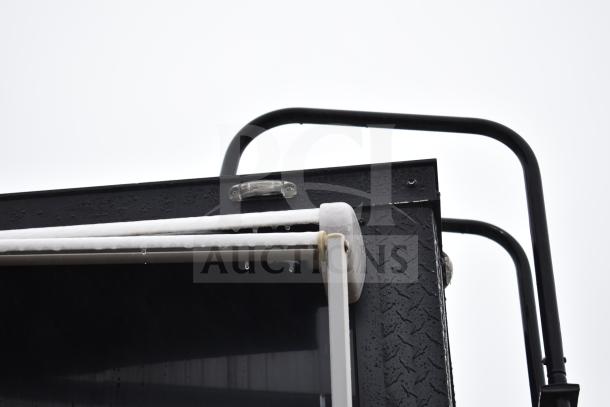 All-black mobile commissary trailer with ice accumulation on awning edge, showing roof details and trailer corner.