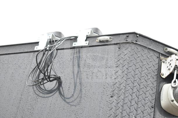 2020 Southern Dimensions Group all-black mobile commissary trailer exterior, featuring electrical wiring and rain droplets.
