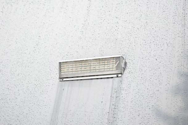 Outdoor LED light on the exterior of a 2020 Southern Dimensions Group mobile trailer, with visible rain droplets on the surface.