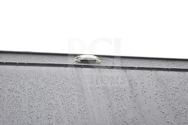 Exterior close-up of a 2020 Southern Dimensions Group all-black mobile commissary trailer with rain droplets on the surface.