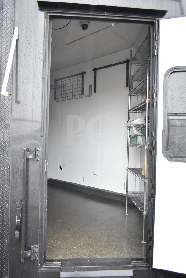 2020 Southern Dimensions Group 8.5' x 20' black mobile trailer interior with wire shelving and IT cabinet.