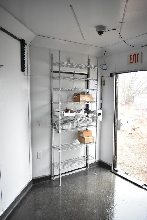 2020 Southern Dimensions mobile commissary trailer interior with wire shelving, boxes, and exit door. Well-maintained.