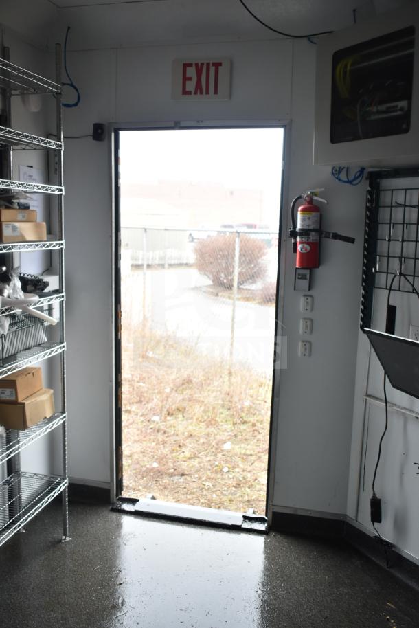 Interior of a 2020 Southern Dimensions Group mobile commissary trailer showing wire shelving, exit door, and mounted fire extinguisher.