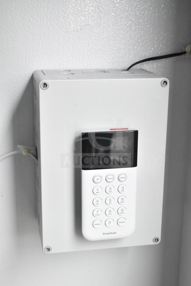 SimpliSafe keypad and control box mounted on a wall, part of security system in mobile command trailer.