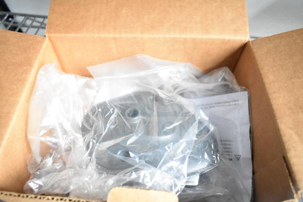 Alt text: Cardboard box containing plastic-wrapped items and documents, possibly parts or accessories for a trailer.