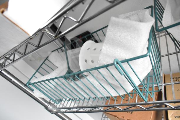 Wire shelving with teal baskets and packaged items, part of the Southern Dimensions Group mobile commissary trailer's interior.