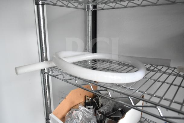 Wire shelving part of the 2020 Southern Dimensions Group 8.5' x 20' mobile trailer, housing a white coil and metal components.