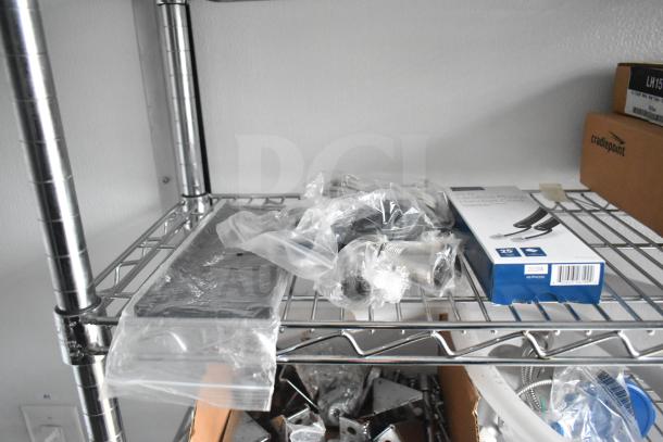 Metal wire shelf inside trailer with packaged hardware and a box labeled "cradlepoint." Items appear intact and organized.
