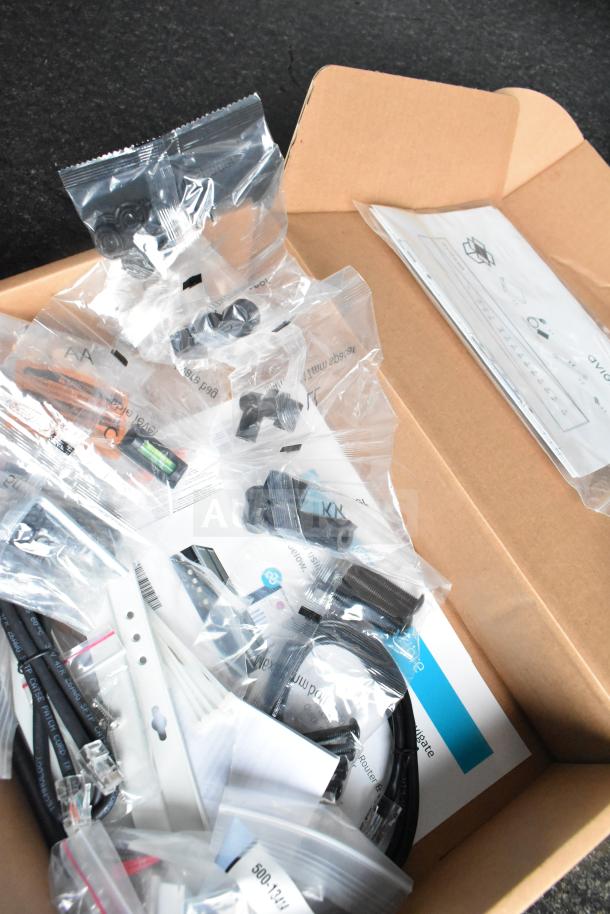 Box containing hardware kits and accessories for setup and installation; includes screws, cables, and mounting brackets.