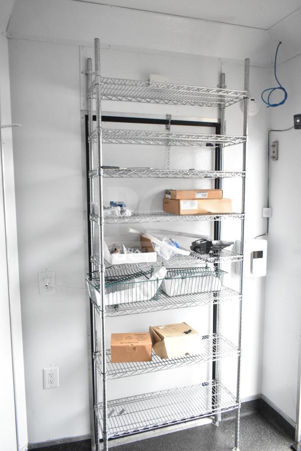 Wire shelving inside 2020 Southern Dimensions mobile trailer, holding boxes and items. Part of 8.5' x 20' all-black model.