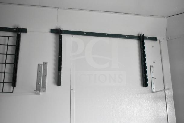 Interior wall of a 2020 Southern Dimensions Group mobile commissary trailer, showing wall-mounted shelving brackets and grid.