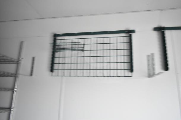 Interior view of the 2020 Southern Dimensions Group mobile trailer featuring wire shelving and storage rack on white walls.