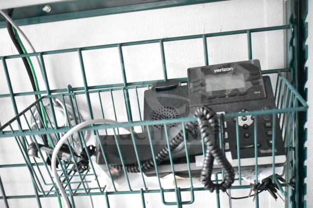 Verizon Yealink T41S phone in metal wire rack with coiled cable and network wiring visible.