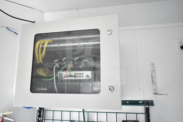 IT/Network cabinet inside a 2020 Southern Dimensions Group trailer, featuring wired connections and CyberPower equipment.