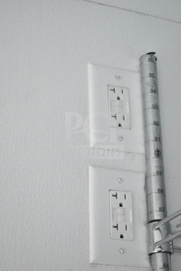 Electrical outlets and a metallic hinge inside a Southern Dimensions Group mobile commissary/command trailer.