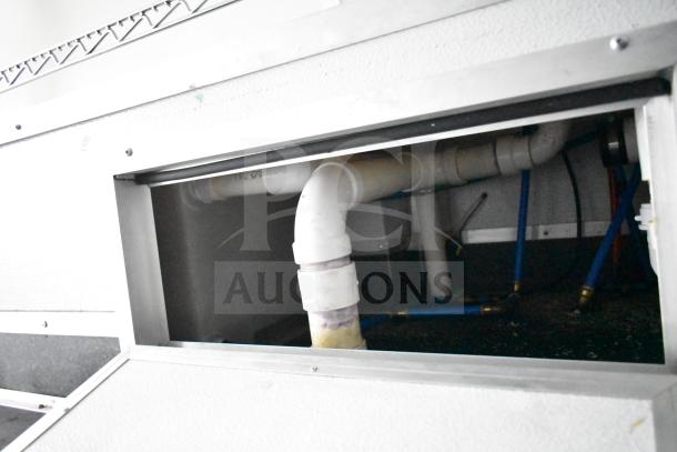 Under-sink plumbing setup inside 2020 Southern Dimensions Group mobile commissary trailer, featuring PVC piping and connections.