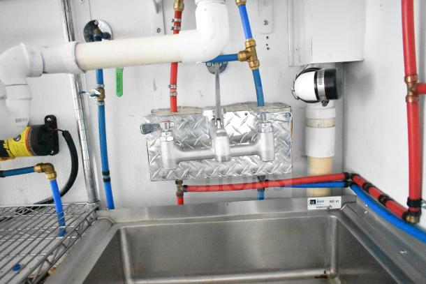 Interior view of a 2020 Southern Dimensions Group trailer, showing plumbing system with dual John Boos sinks and piping.