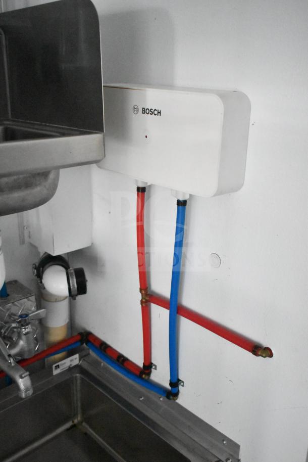 Bosch water heater with connected red and blue hoses above dual John Boos sinks in a 2020 Southern Dimensions Group trailer.