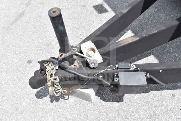 Trailer hitch of a 2021 Rock Solid Cargo 28ft Commercial Food Trailer. Features include safety chains and electrical connections.