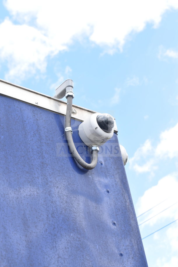 Security camera mounted on a blue exterior of the 2021 Rock Solid Cargo 28ft Commercial Food Trailer.
