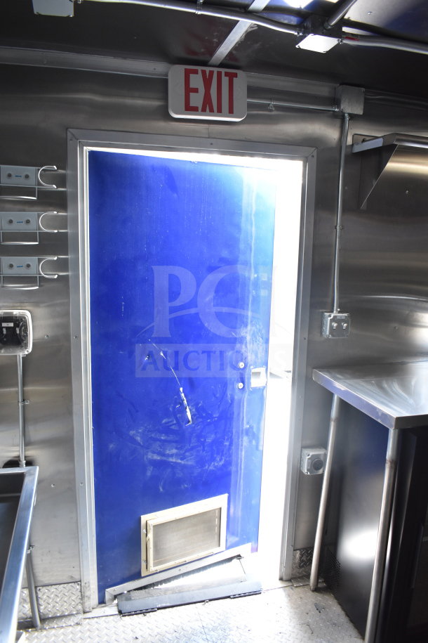 2021 Rock Solid Cargo 28ft food trailer interior showing stainless steel surfaces, blue exit door, and ventilation.