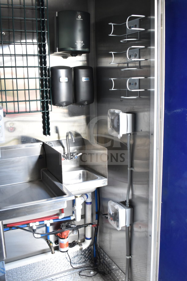2021 Rock Solid Cargo 28ft food trailer interior featuring a sink, multiple dispensers, and organized plumbing system.