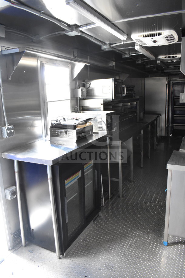 2021 Rock Solid Cargo 28ft food trailer interior with CaptiveAire hood, refrigeration, stainless steel counters, and Nieco charbroiler.