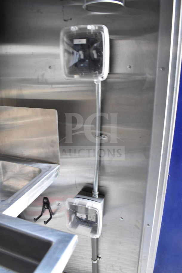 Alt text: Interior view of a 2021 Rock Solid Cargo food trailer, featuring visible electrical outlets and stainless steel surfaces.