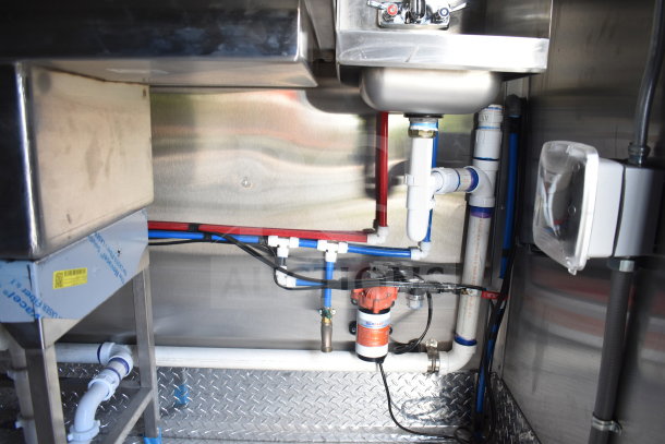 New 2021 Rock Solid Cargo 28ft food trailer interior plumbing and equipment, featuring stainless steel sink and connections.