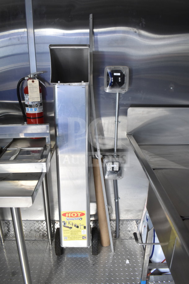 New 2021 Rock Solid Cargo 28ft food trailer interior with stainless steel equipment, fire extinguisher, and electrical outlets.