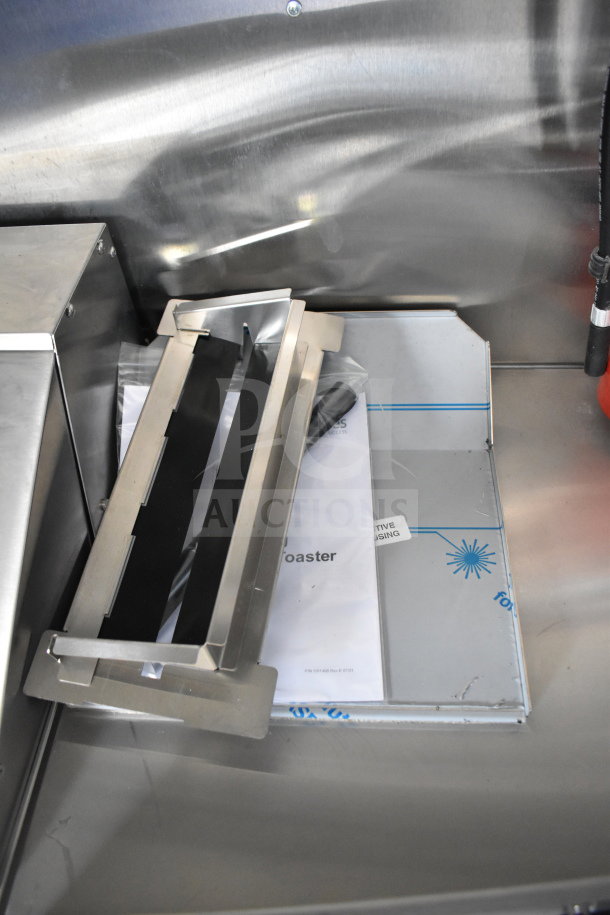 Metal components and documents inside a 2021 Rock Solid Cargo 28ft food trailer, featuring CaptiveAire hood and Nieco charbroiler.