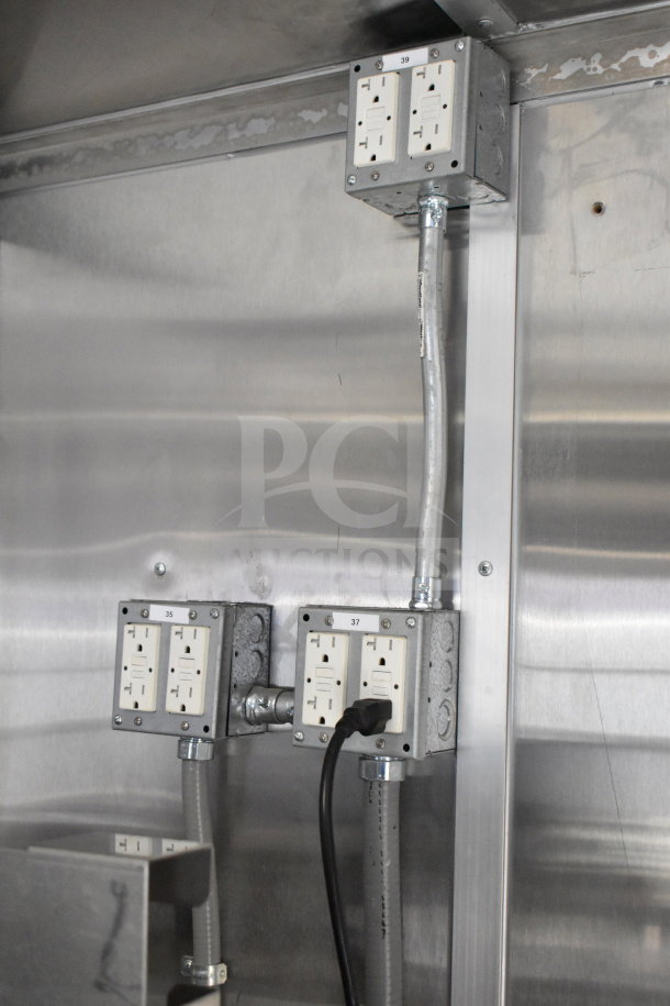 New 2021 Rock Solid Cargo 28ft food trailer's electrical outlets on stainless steel interior wall, labeled 35, 37, 39.