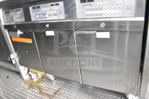 Stainless steel interior of a 2021 Rock Solid Cargo 28ft food trailer, featuring control panels and refrigeration units.