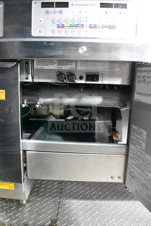 New 2021 Rock Solid Cargo 28ft food trailer interior, featuring Frymaster system controls, stainless steel build, and labels.