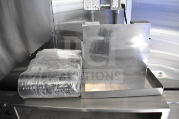 Interior of 2021 Rock Solid Cargo 28ft food trailer with stainless steel fixtures, electrical outlets, and packaging on counter.