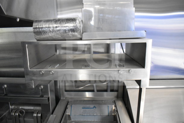 New 2021 Rock Solid Cargo 28ft food trailer interior, featuring CaptiveAire hood system and stainless steel equipment.