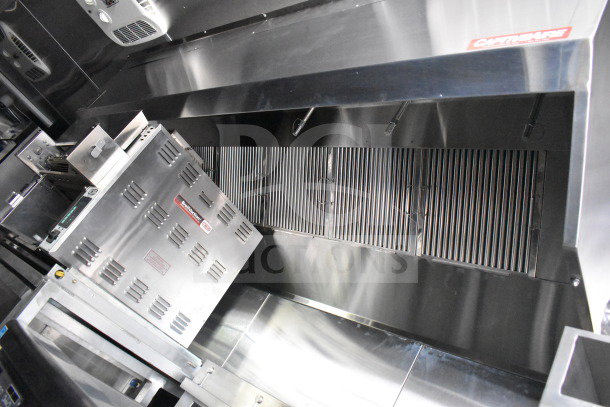 New 2021 Rock Solid Cargo 28ft food trailer interior, featuring CaptiveAire hood system, Bellwether oven, stainless steel finish.