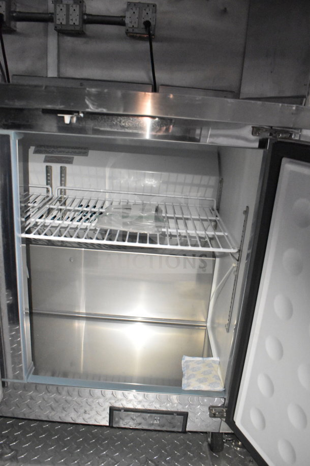 Rock Solid Cargo 28ft food trailer interior showing open commercial refrigerator with chrome shelving.
