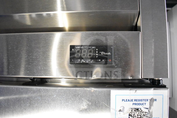 Stainless steel panel with True refrigeration control display on a new 2021 Rock Solid Cargo 28ft food trailer. Visible label instructs product registration.