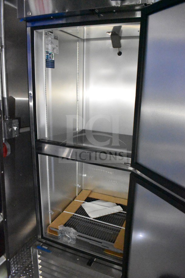 New 2021 Rock Solid Cargo 28ft food trailer interior, featuring refrigeration package; open doors, stainless steel finish.
