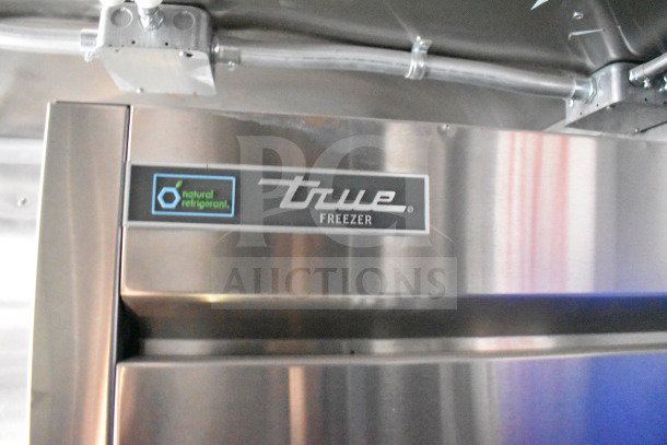 True Freezer label with natural refrigerant logo on stainless steel surface inside a commercial food trailer.