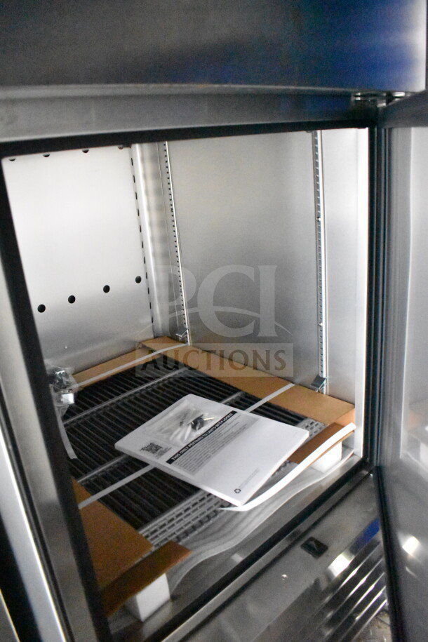 Interior of a 2021 Rock Solid Cargo 28ft food trailer showing shelving and documentation, ready for setup.