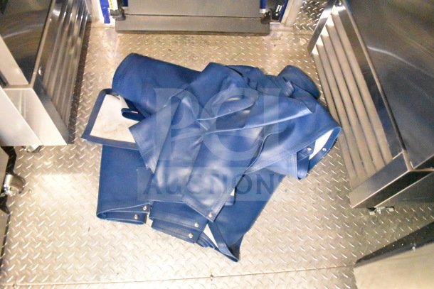 Interior of a 2021 Rock Solid Cargo 28ft food trailer with diamond plate flooring and folded blue tarps on the floor.