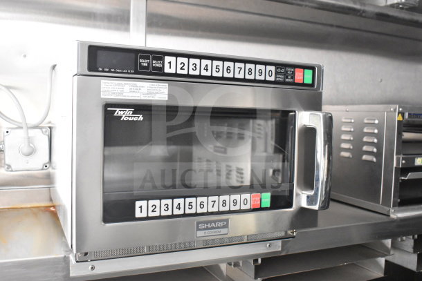 Sharp microwave R-CD1800M in commercial food trailer, stainless steel finish, keypad controls, mounted on a shelf.