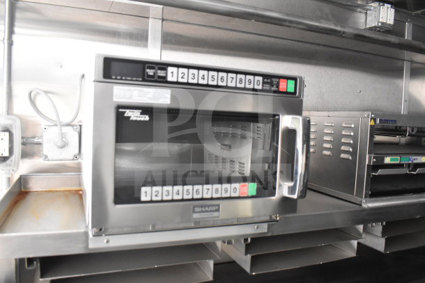 New Sharp microwave oven in 2021 Rock Solid Cargo 28ft food trailer, featuring a CaptiveAire hood and Nieco charbroiler.