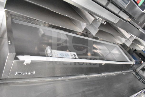2021 Rock Solid Cargo 28ft food trailer interior with CaptiveAire hood and Nieco charbroiler, featuring stainless steel finish.