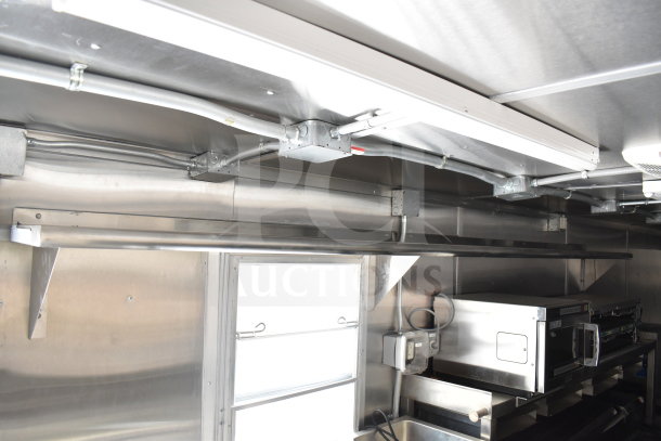 New 2021 Rock Solid Cargo 28ft food trailer interior featuring CaptiveAire hood, refrigeration, and Nieco charbroiler.